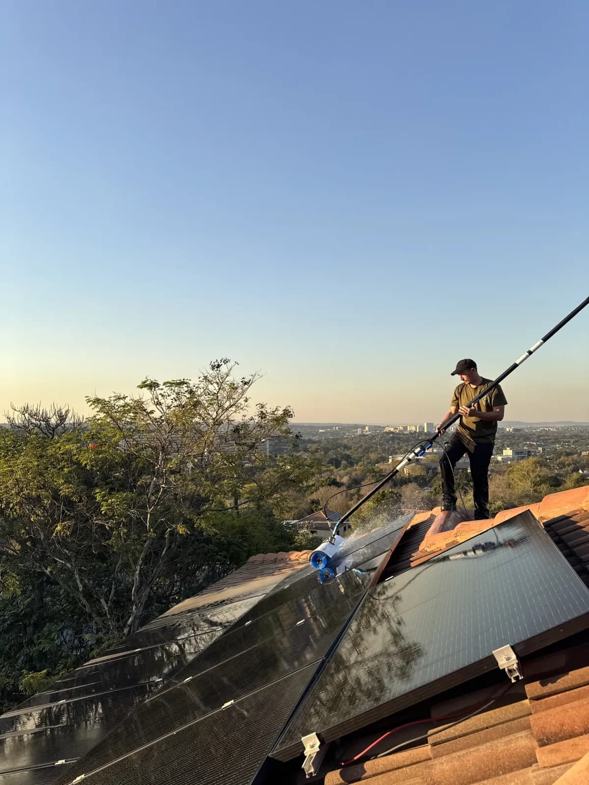 HelioClean technician cleaning solar panels with pure water