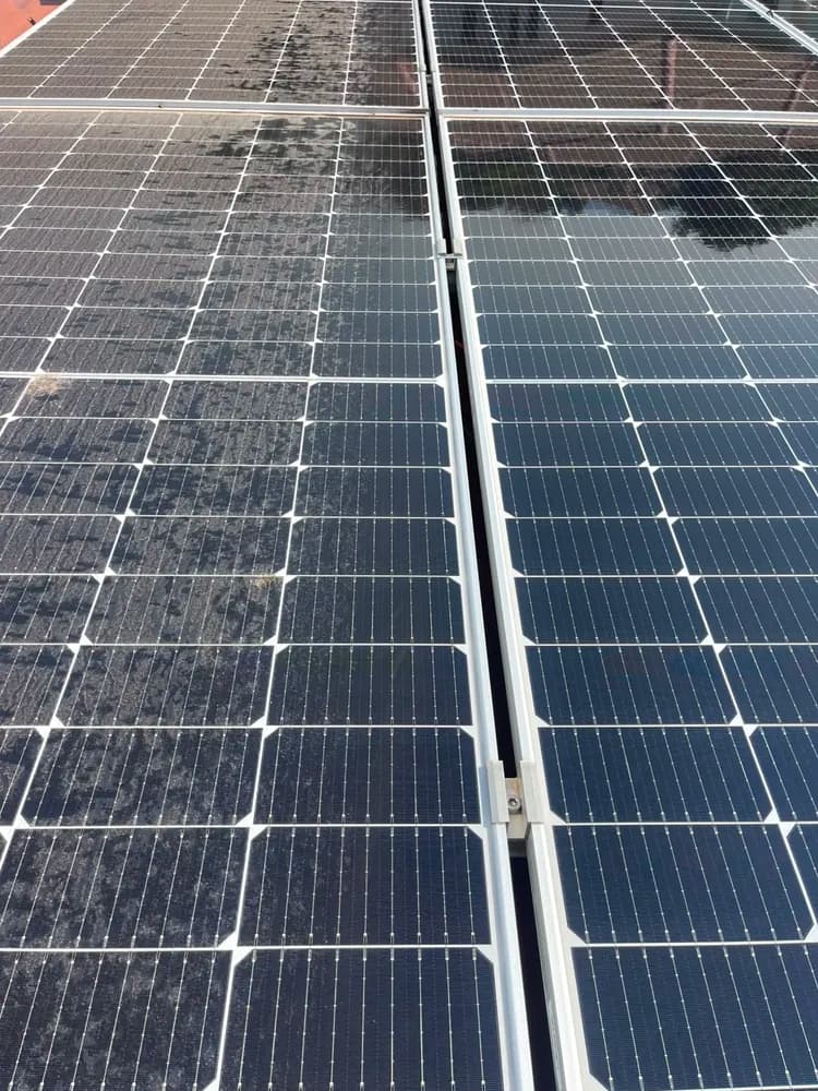 Side-by-side dirty and clean solar panels showing the contrast after a pure-water pass