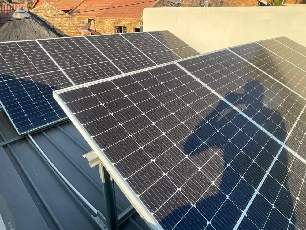 Soiled solar panels on a corrugated metal roof before cleaning