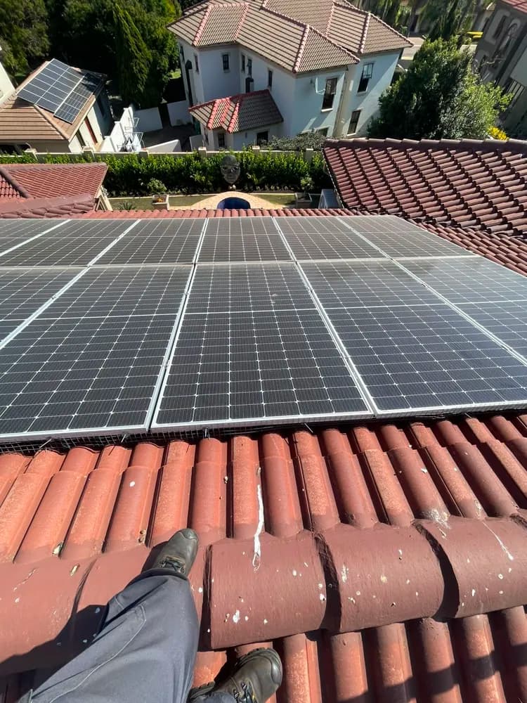 Soiled solar panels on a red-tile residential roof before cleaning
